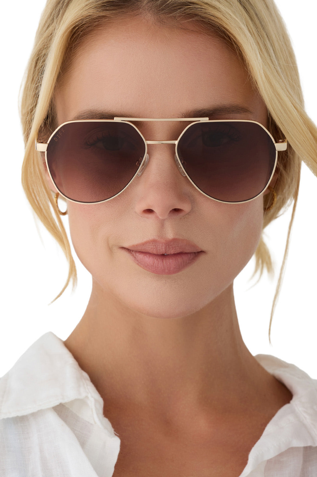Woman wearing aviator sunglasses with a plain background