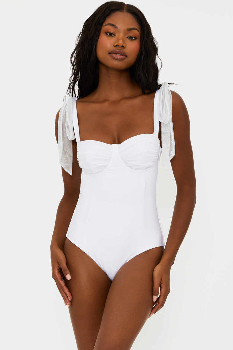 A white one-piece swimsuit with delicate straps that tie at the shoulders and ruched underwire cups with metallic threading.