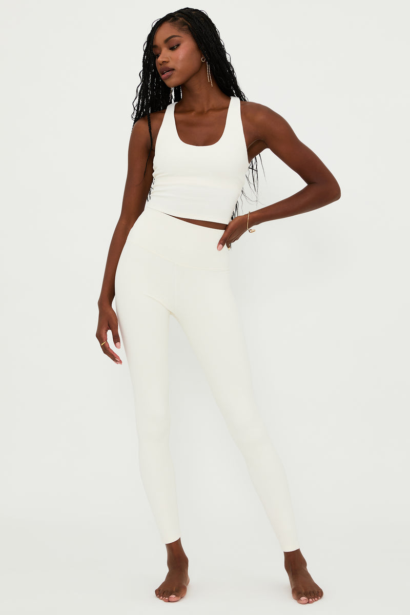 A model wearing high-rise full-length white legging with a waffle texture, paired with a matching white cropped top.