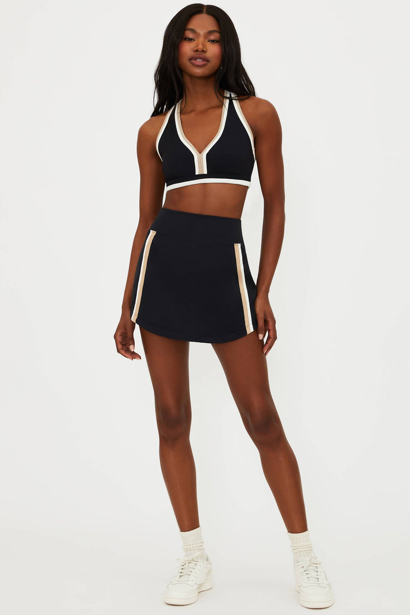 black active skirt and sports bra with tan and white contrast trim details