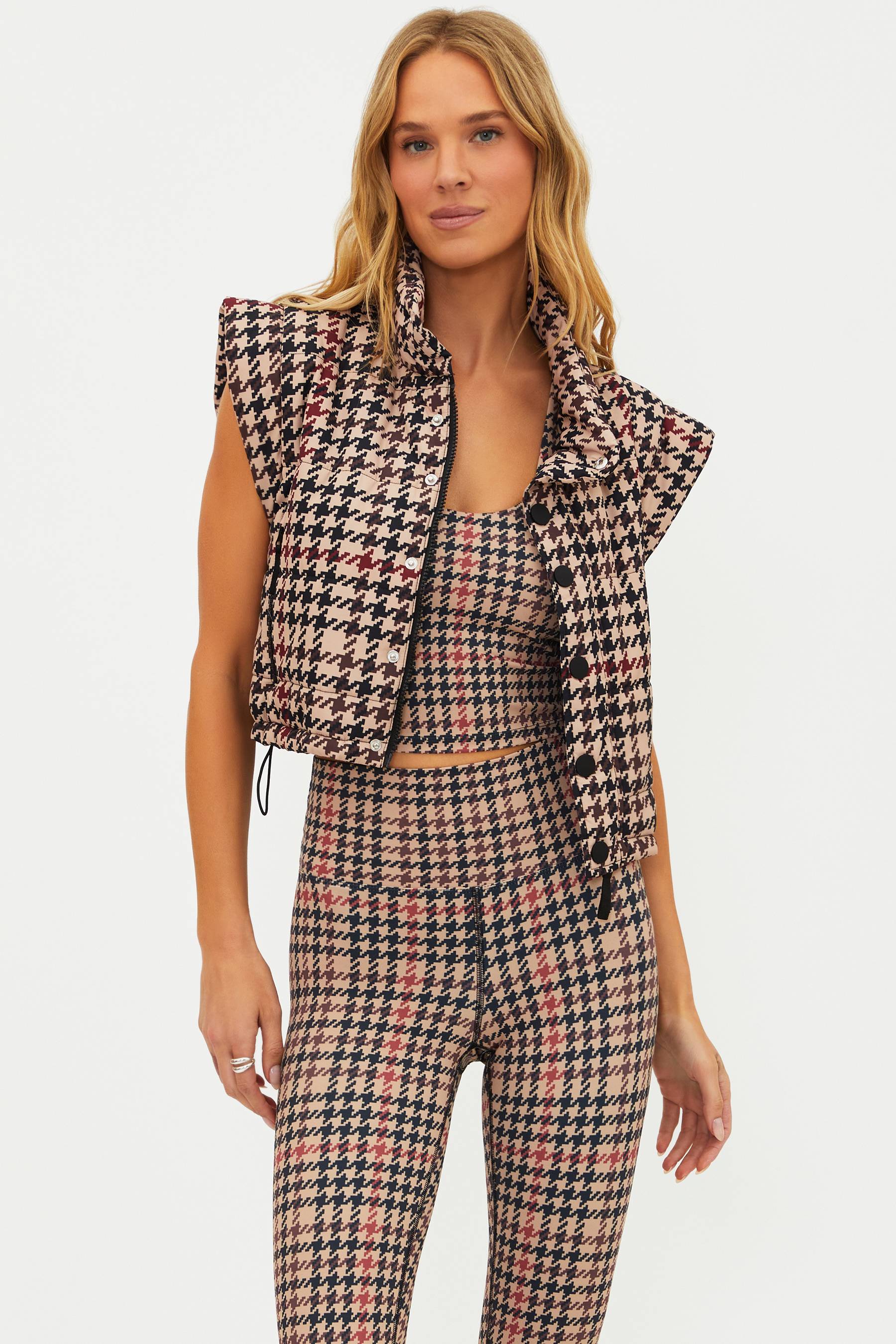Woman wearing a houndstooth patterned outfit on a white background