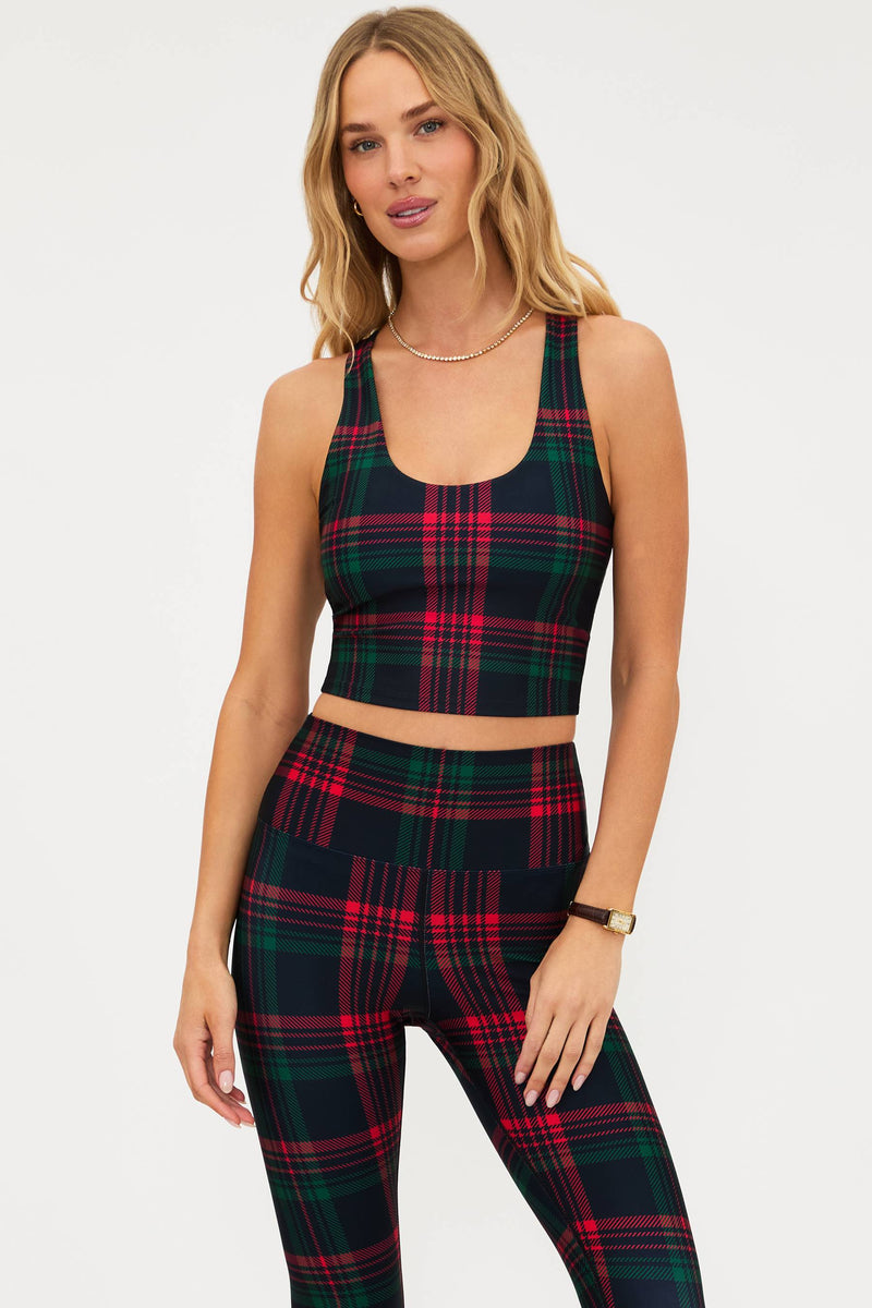 Woman wearing a plaid top and leggings set on a white background
