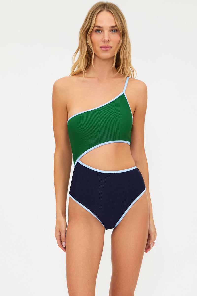 Woman wearing a green and navy one-piece swimsuit on a white background