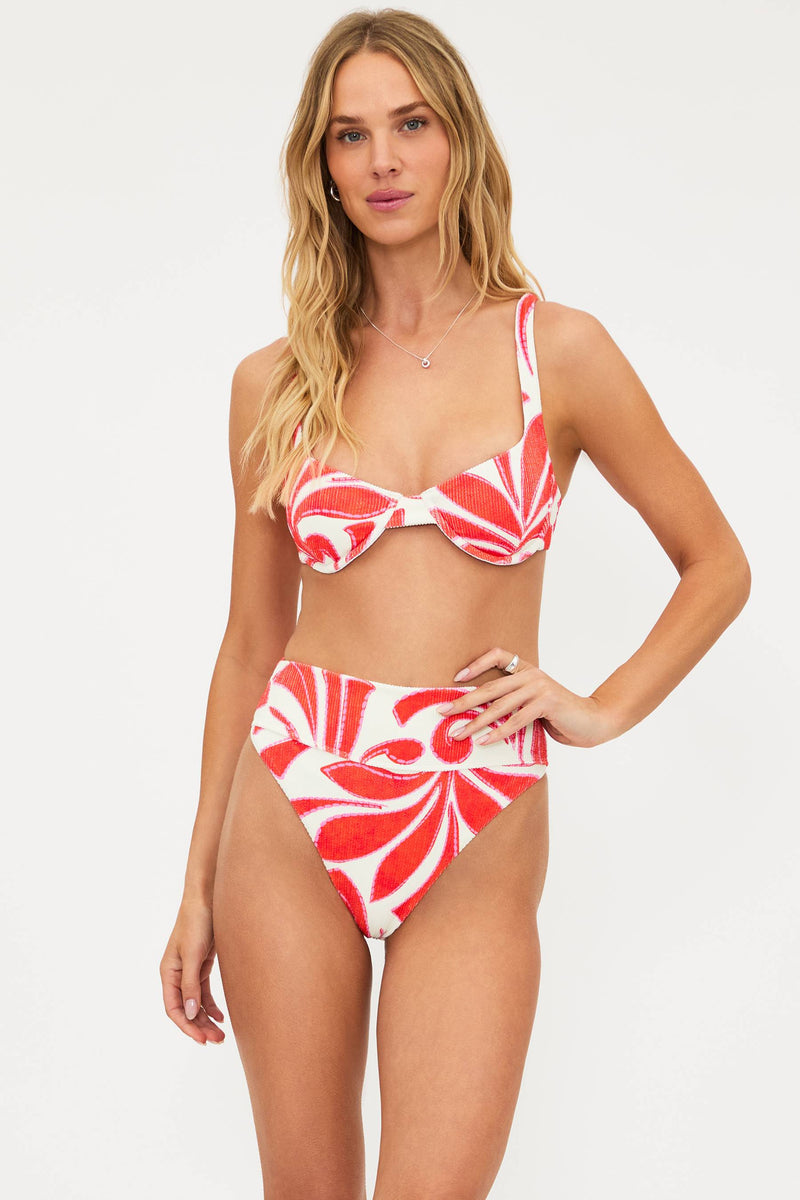 Woman wearing a red and white patterned bikini on a white background