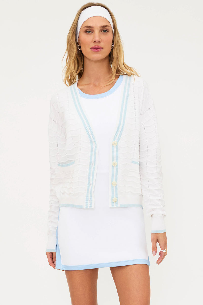 Woman wearing a white dress with light blue accents on a white background