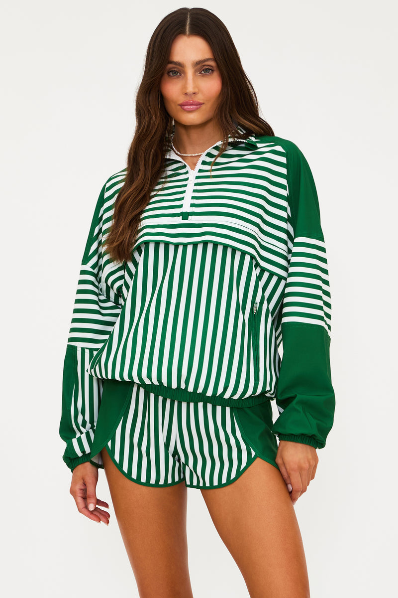 Woman wearing a green and white striped outfit on a plain background
