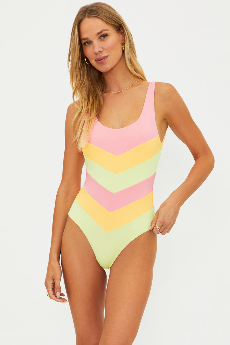 Woman wearing a colorful chevron patterned swimsuit on a white background
