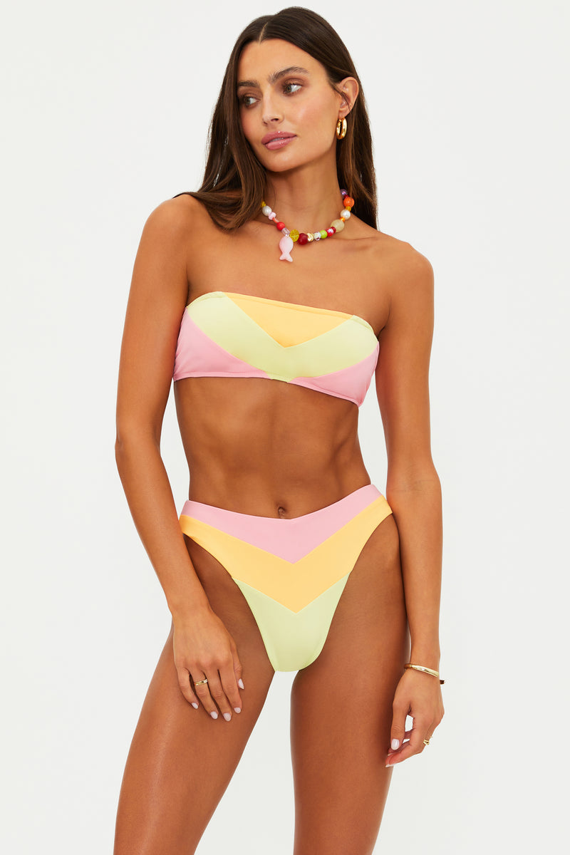 Woman wearing a colorful bikini set on a plain background