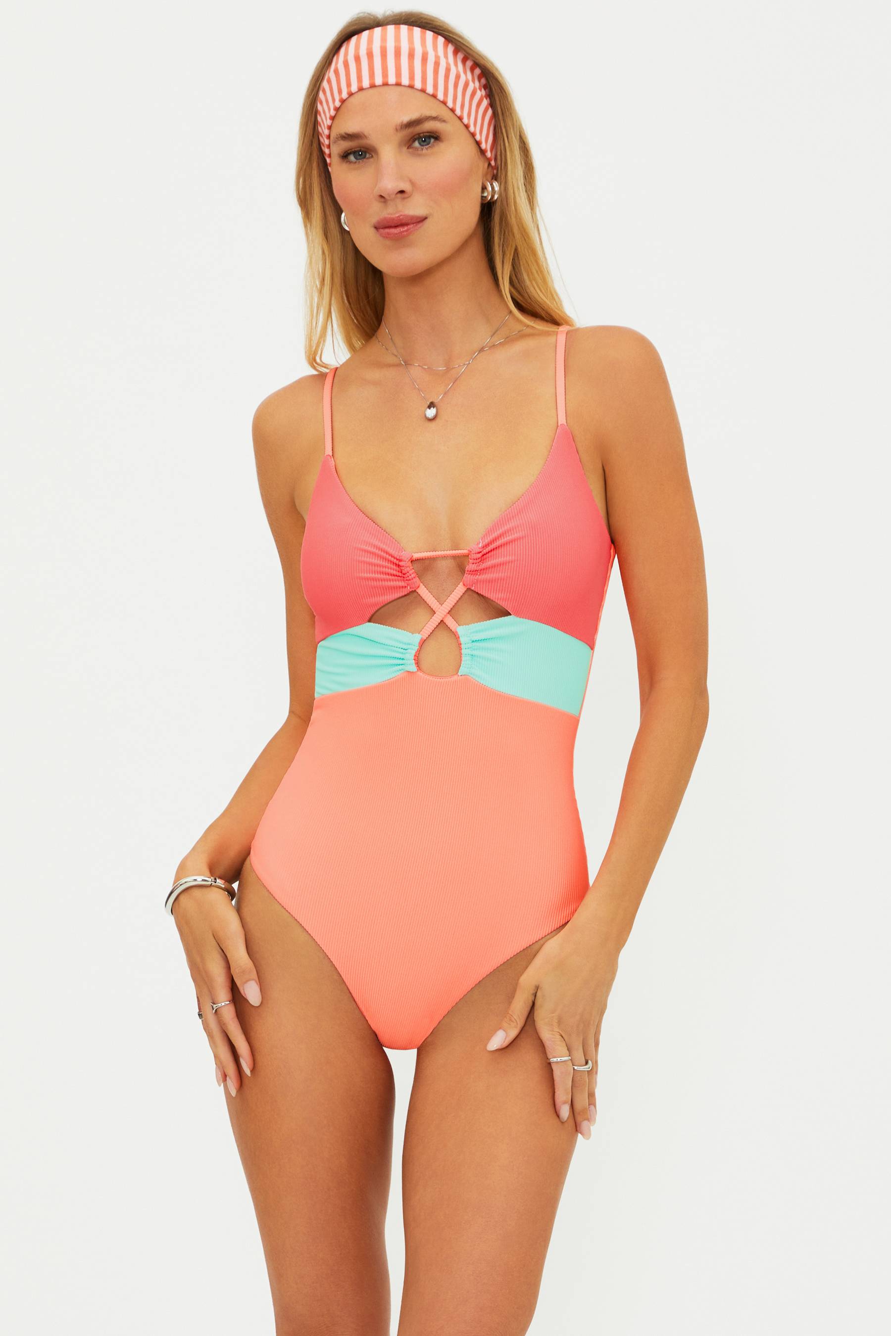 Woman wearing a colorful one-piece swimsuit with a white background