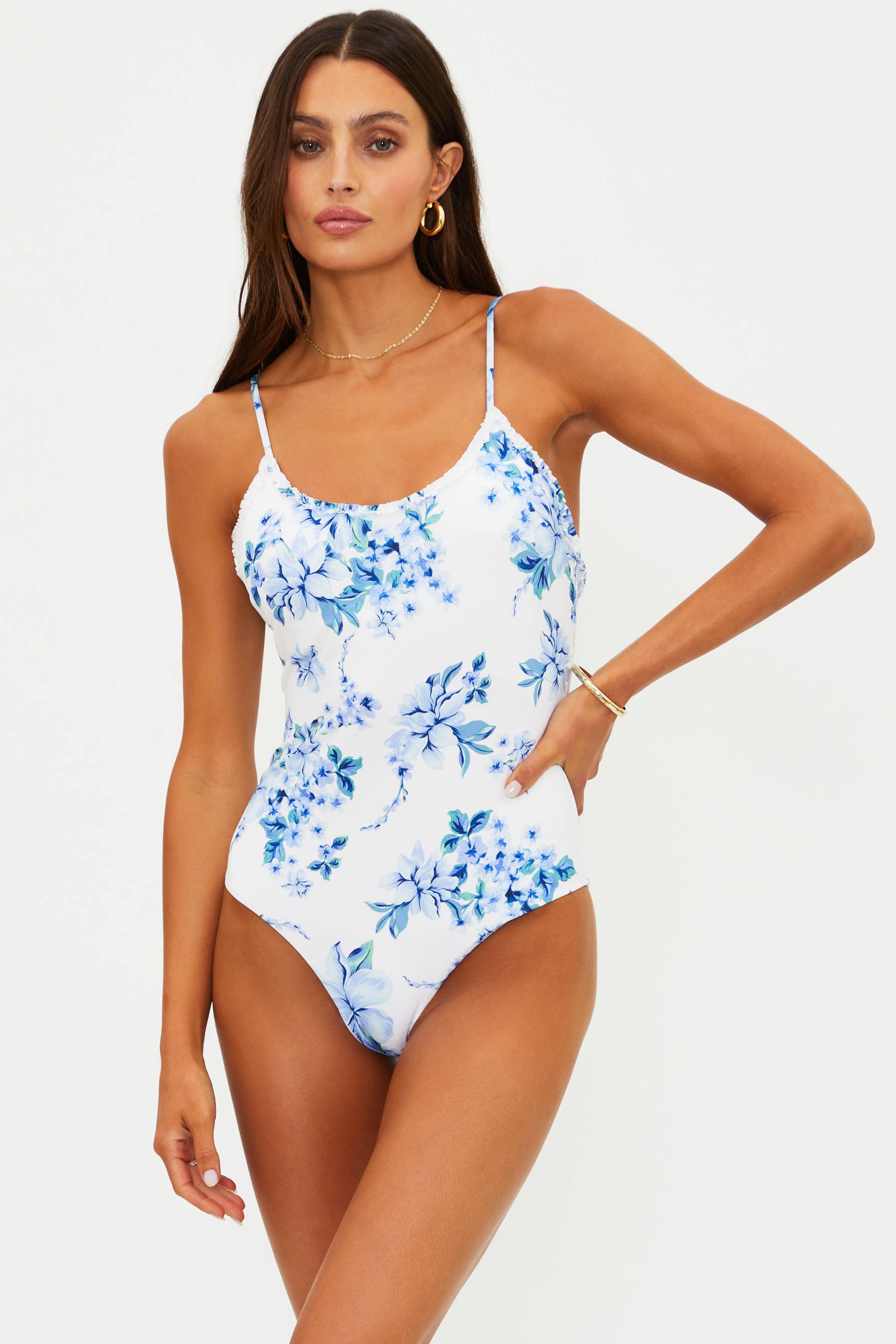 Woman wearing a blue floral one-piece swimsuit on a white background
