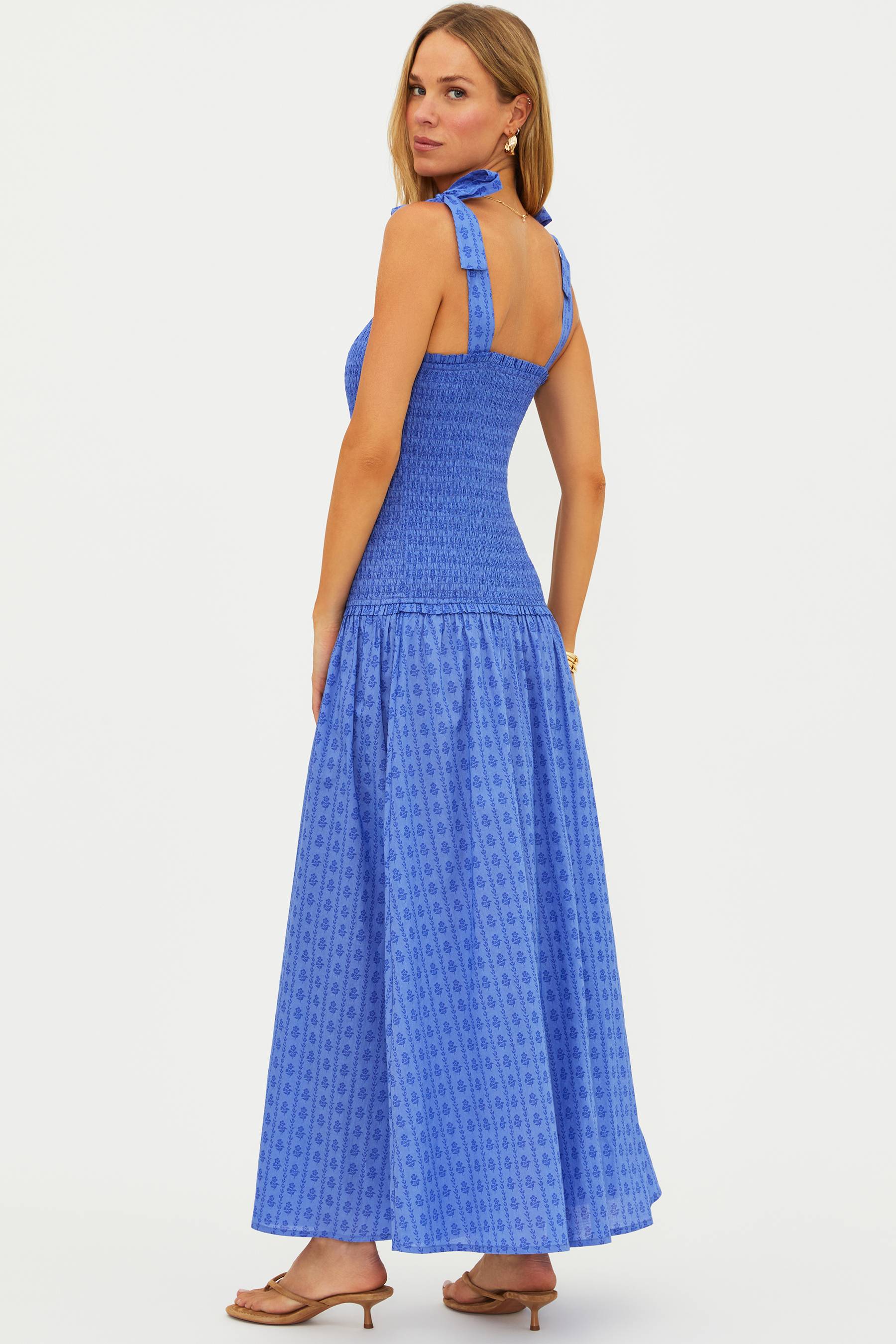 Woman wearing a blue patterned dress on a white background