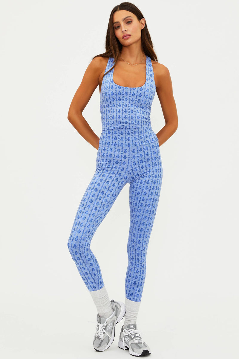 Woman wearing a blue patterned jumpsuit on a white background