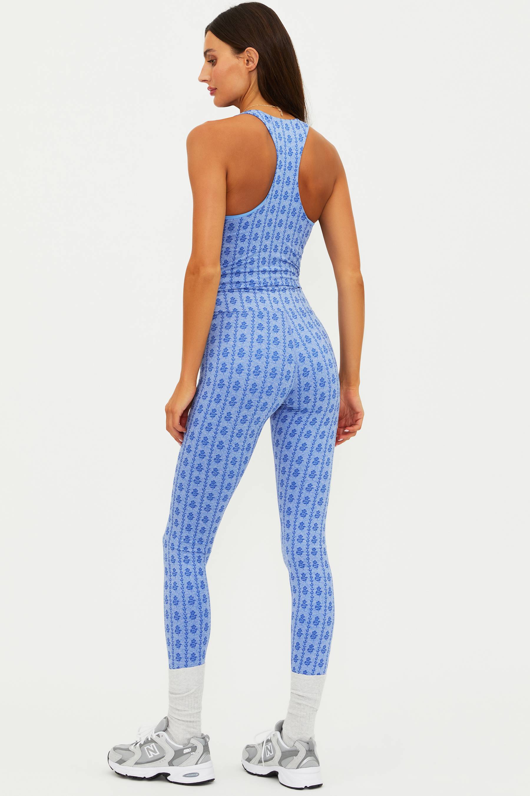 Woman wearing a blue patterned jumpsuit on a white background