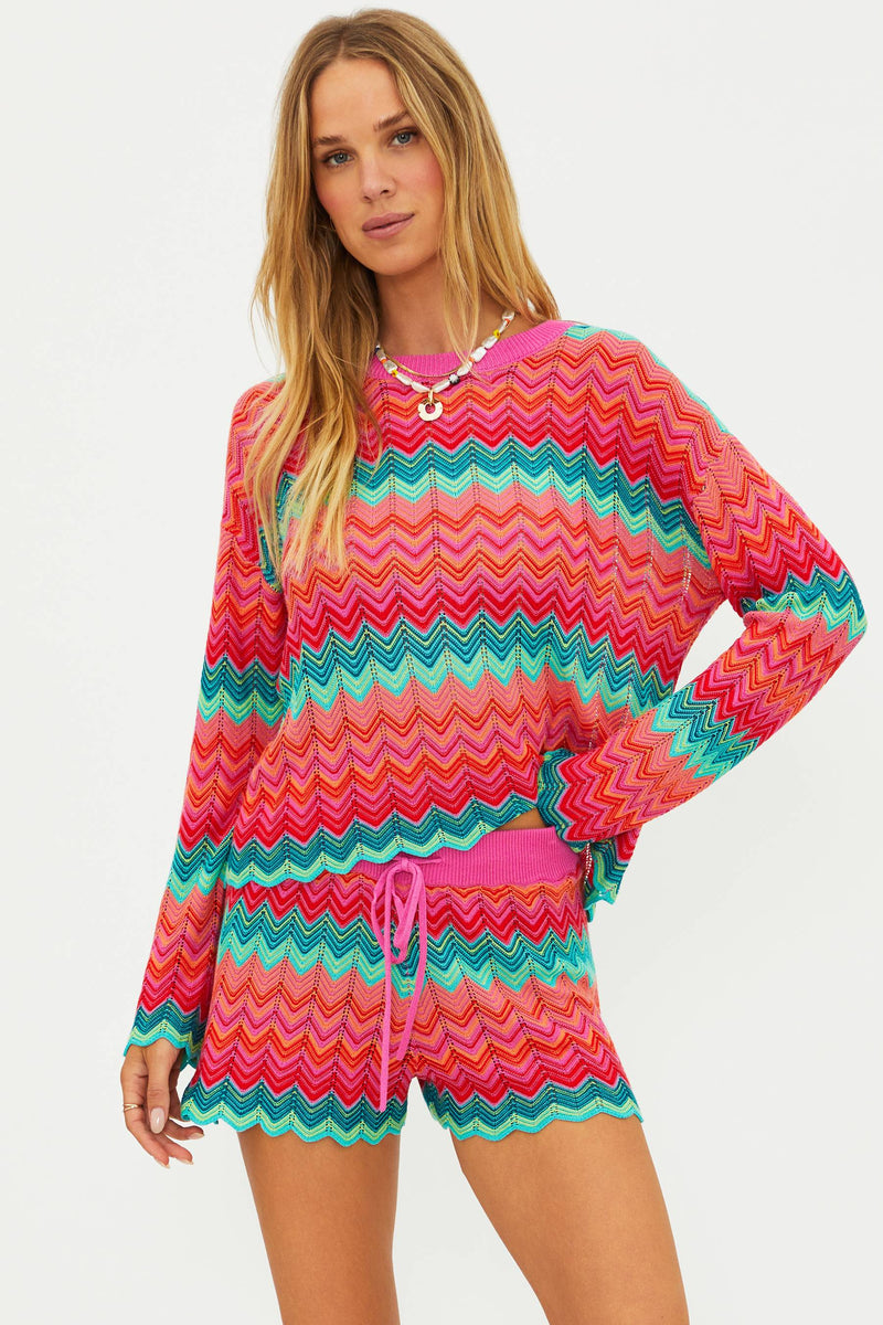 Woman wearing a colorful zigzag patterned outfit on a white background