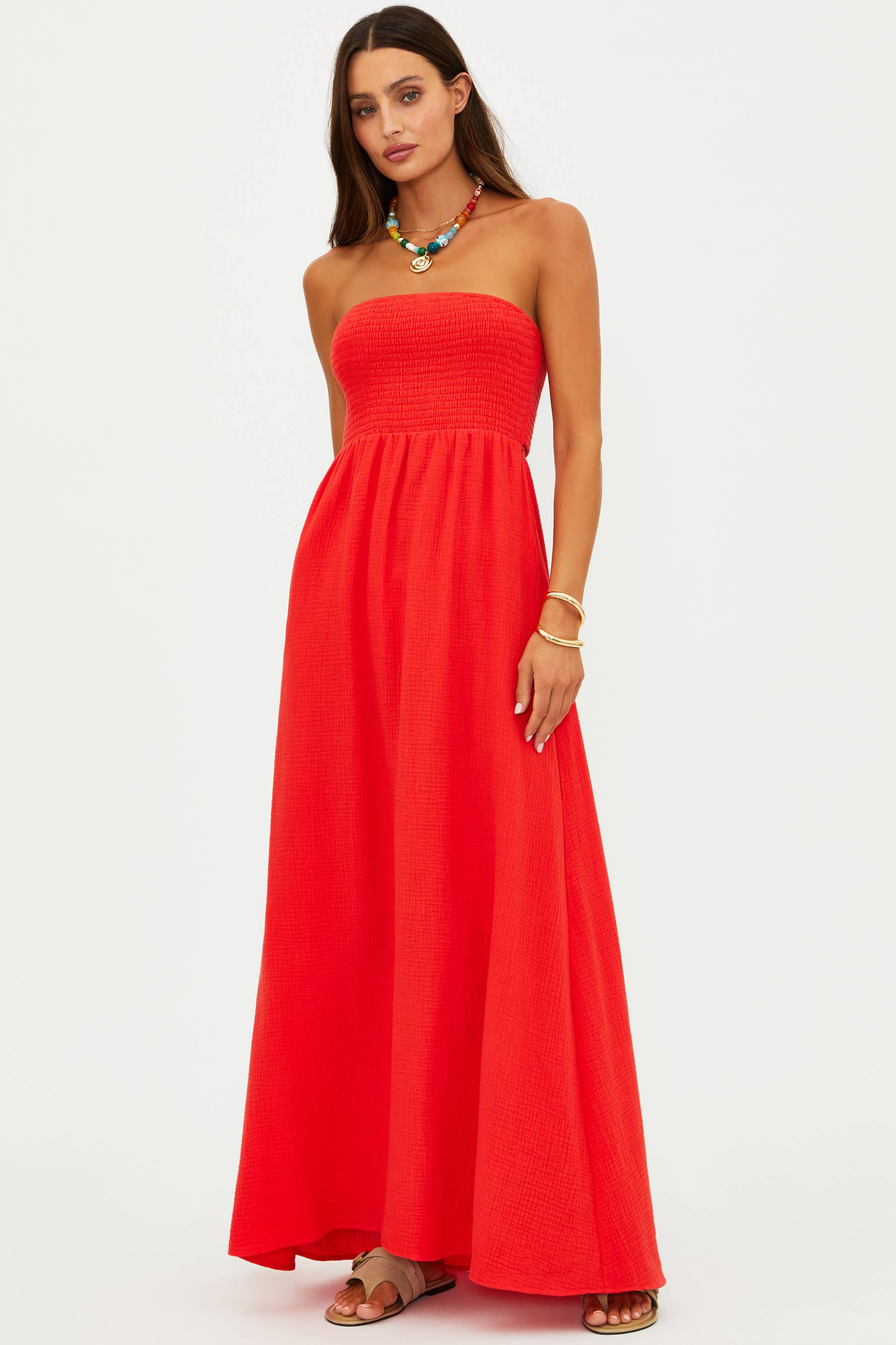 Woman wearing a strapless red dress on a white background
