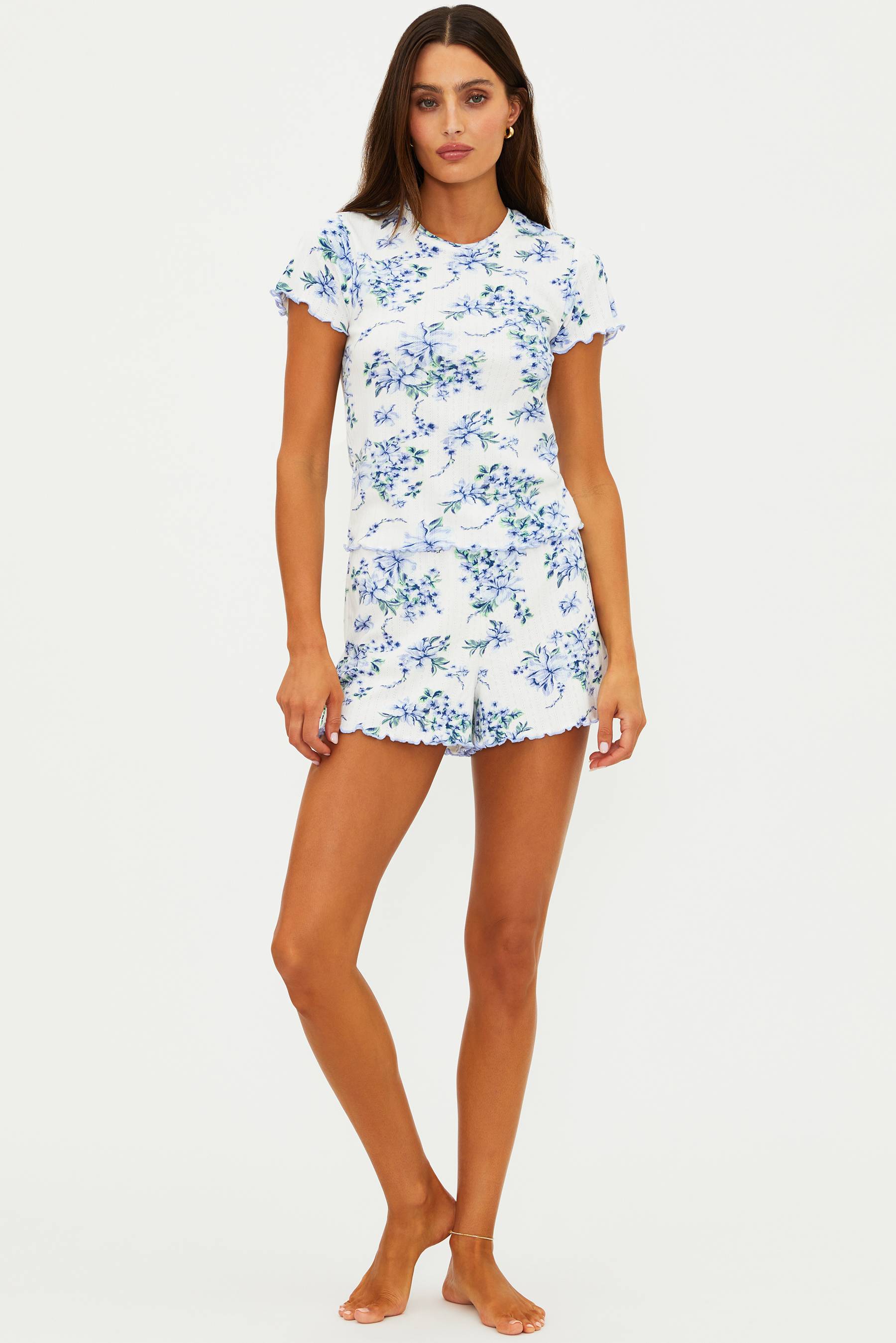 Woman wearing a white dress with blue floral pattern on a white background