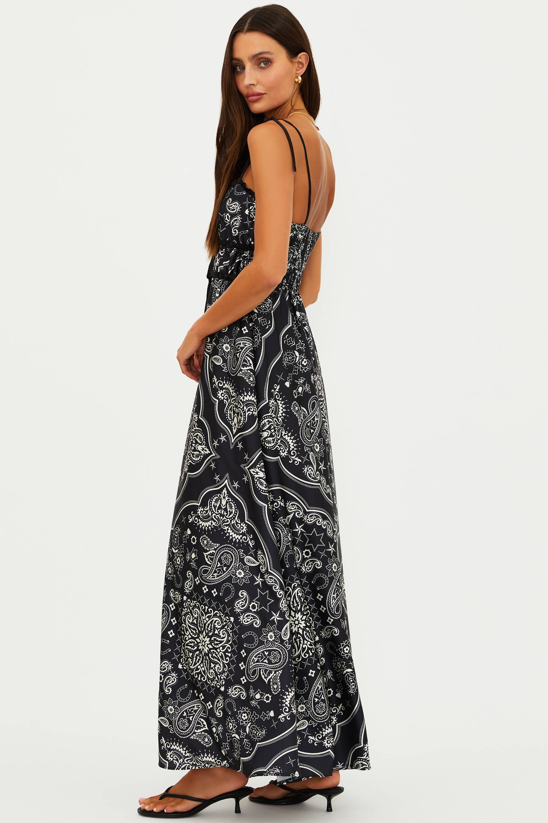 Woman wearing a black floral patterned dress on a white background