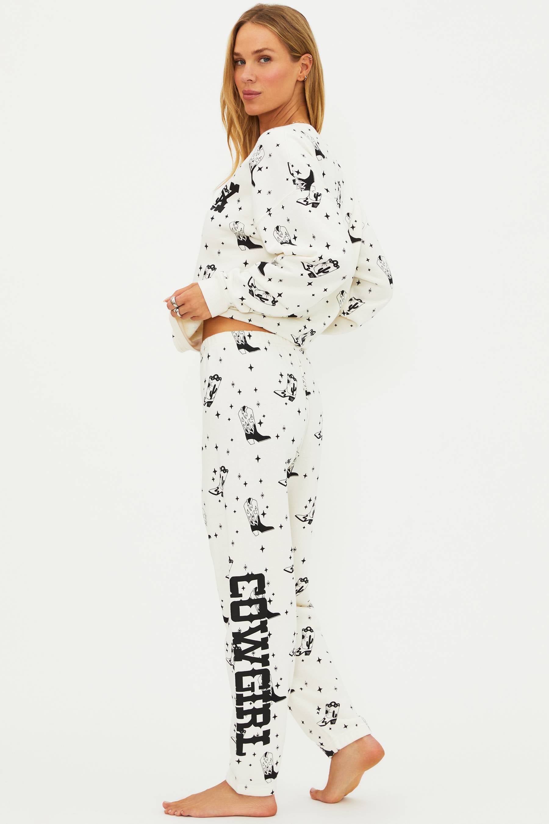 Woman wearing a white pajama set with black patterns on a white background