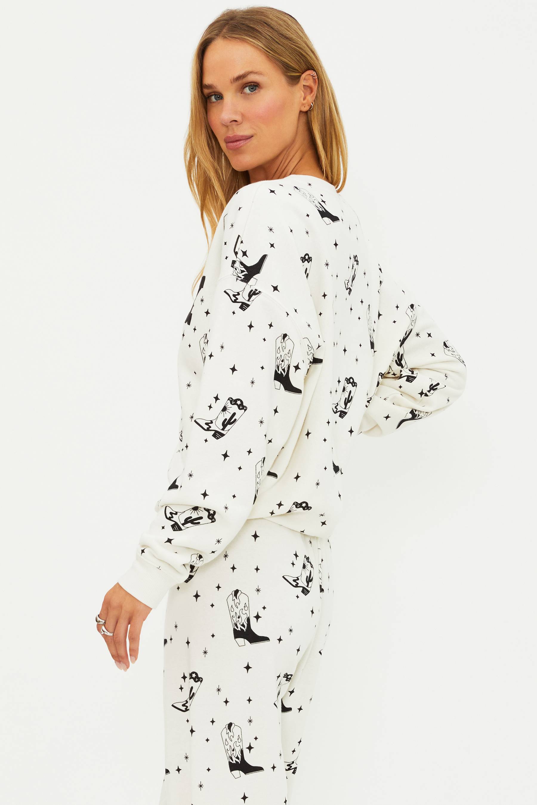 Woman wearing a white onesie with black animal prints on a white background