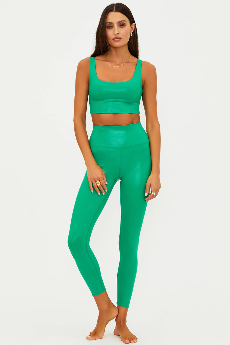 Woman wearing a green athletic outfit on a white background