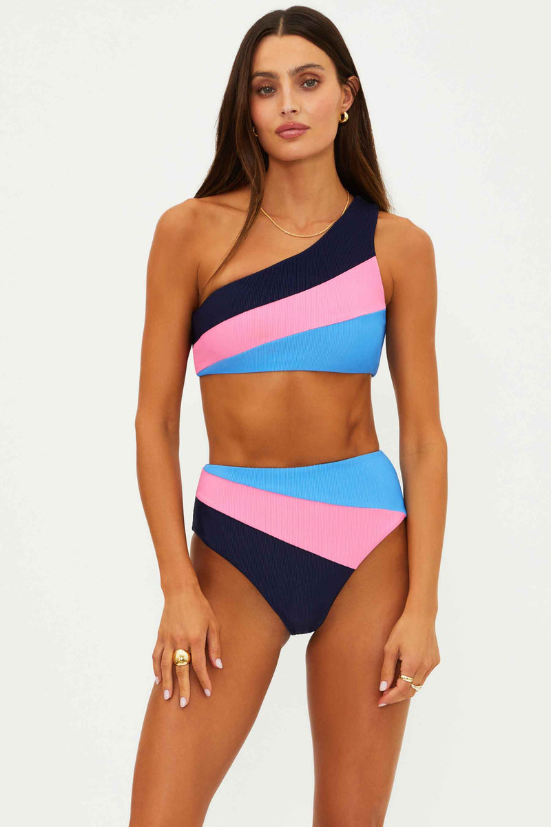 Woman wearing a colorful one-shoulder bikini set on a white background
