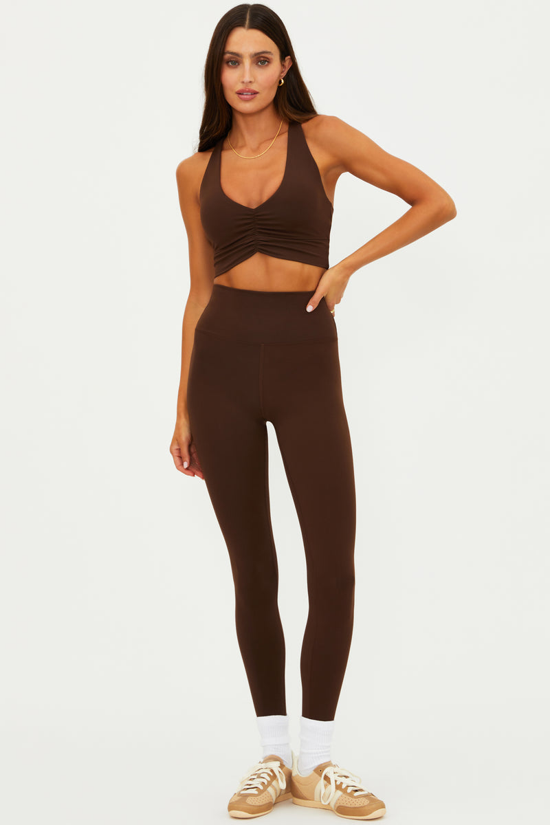 Woman wearing a brown athletic outfit on a white background