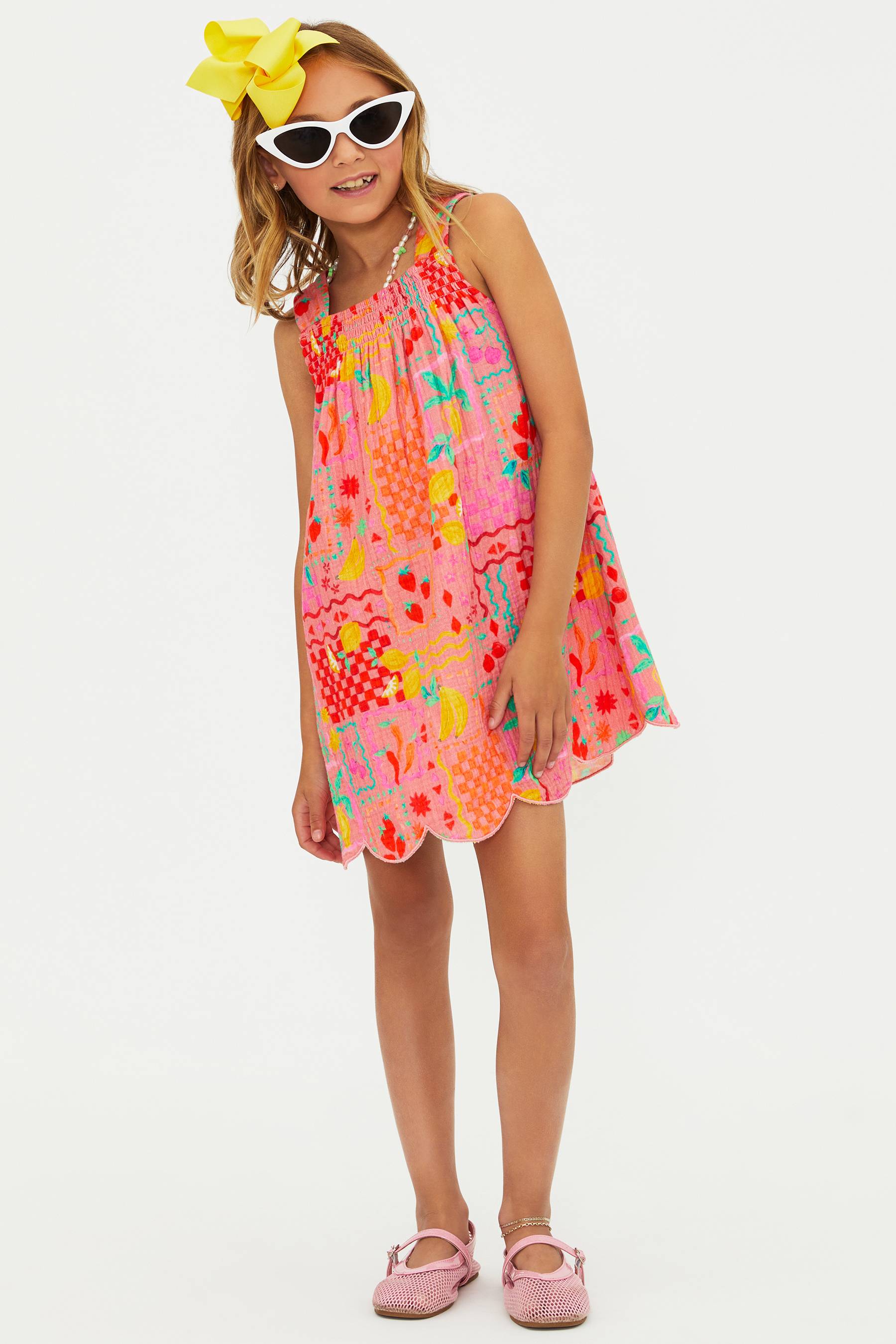 Young girl wearing a colorful floral dress on a white background