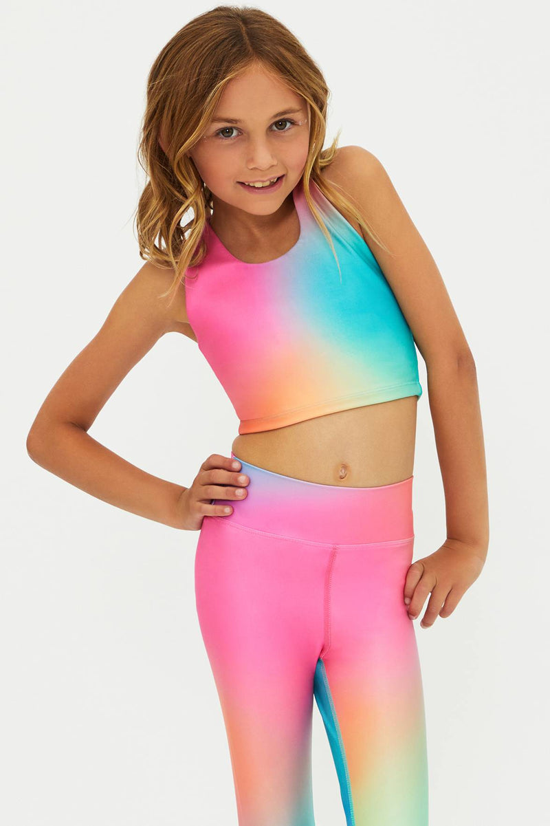 Young girl wearing a colorful gradient outfit on a white background