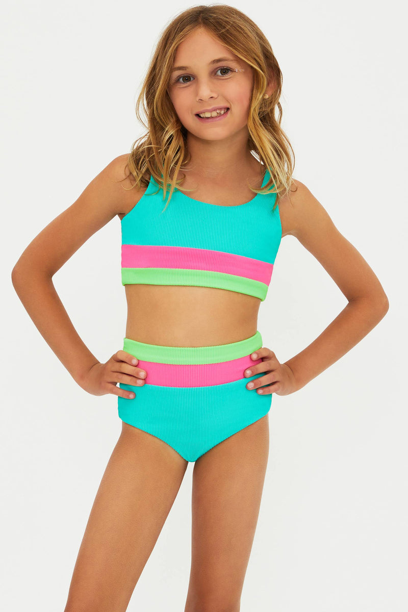 Young girl wearing a colorful two-piece swimsuit on a white background