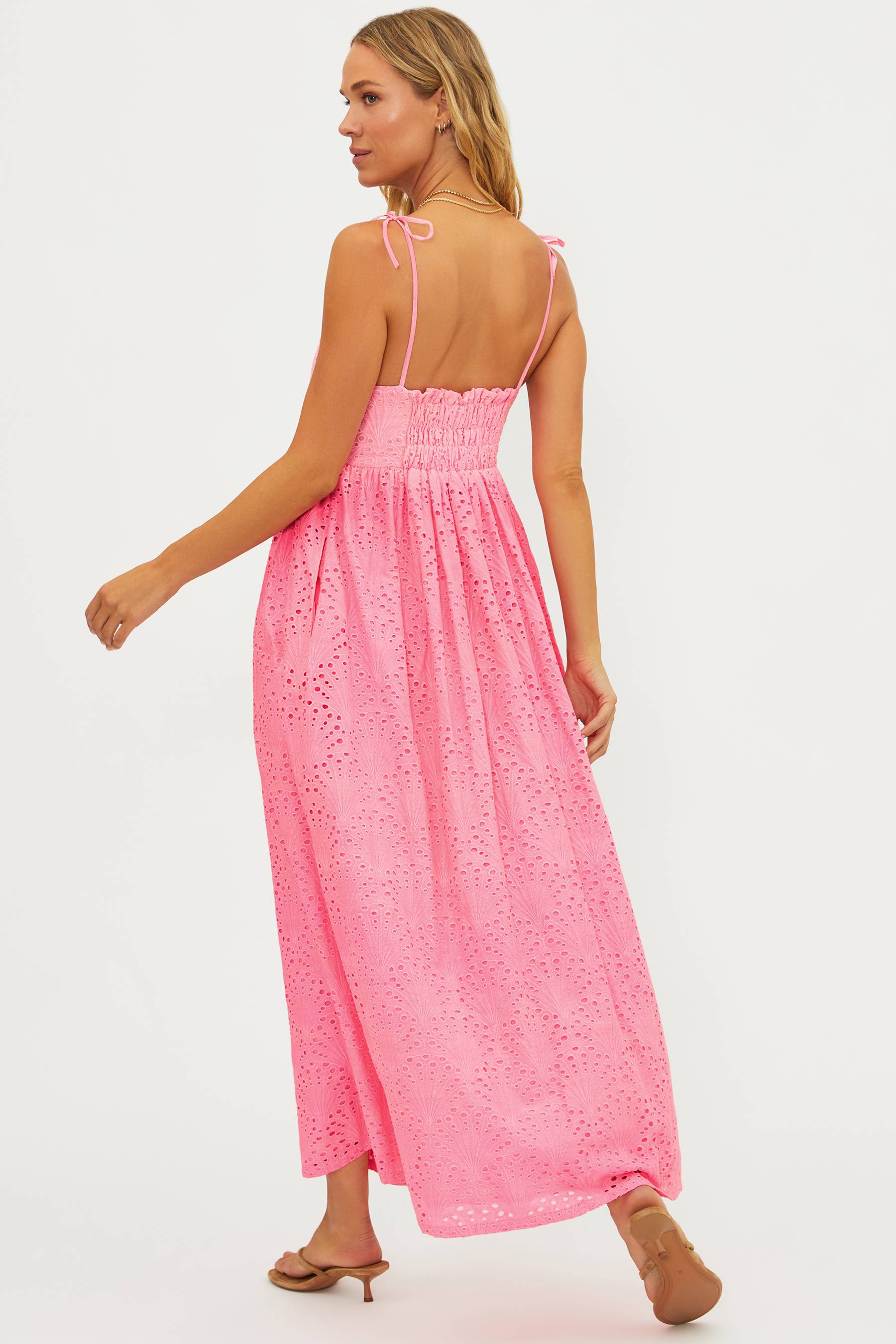 Woman wearing a pink lace dress on a white background