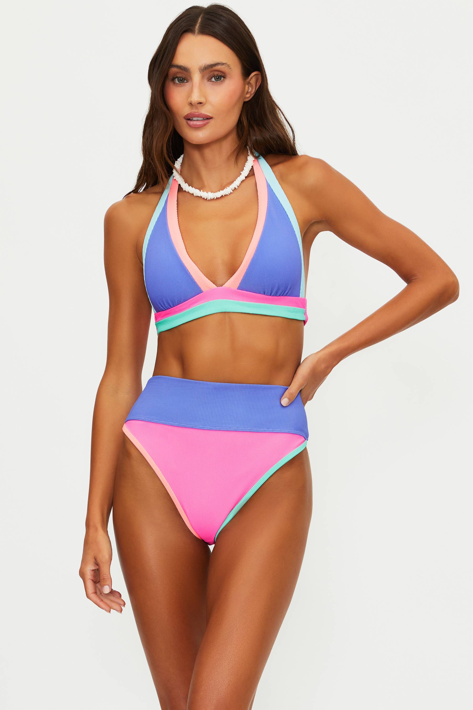 Woman wearing a colorful bikini set on a plain background