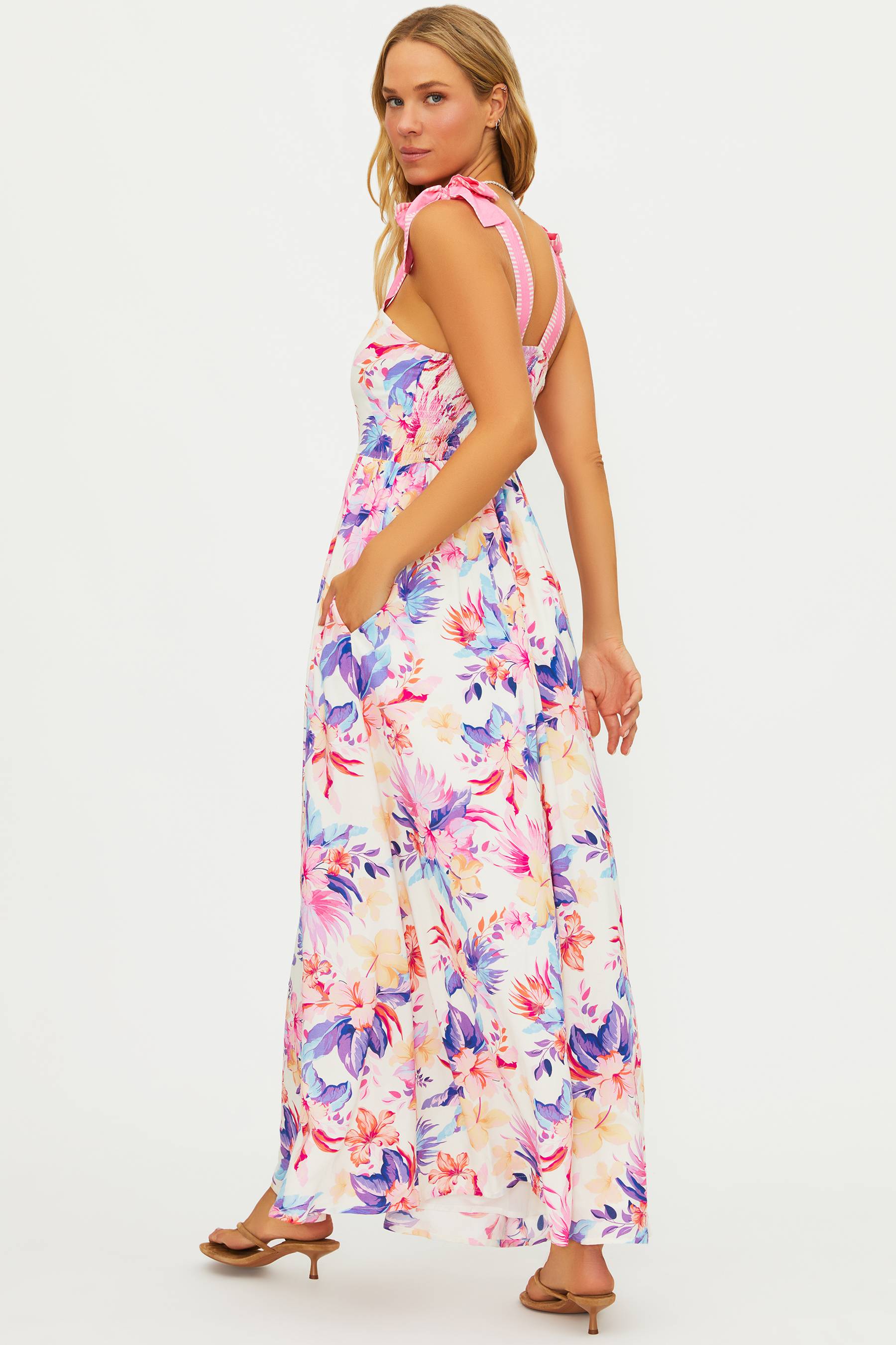 Woman wearing a colorful floral dress on a white background