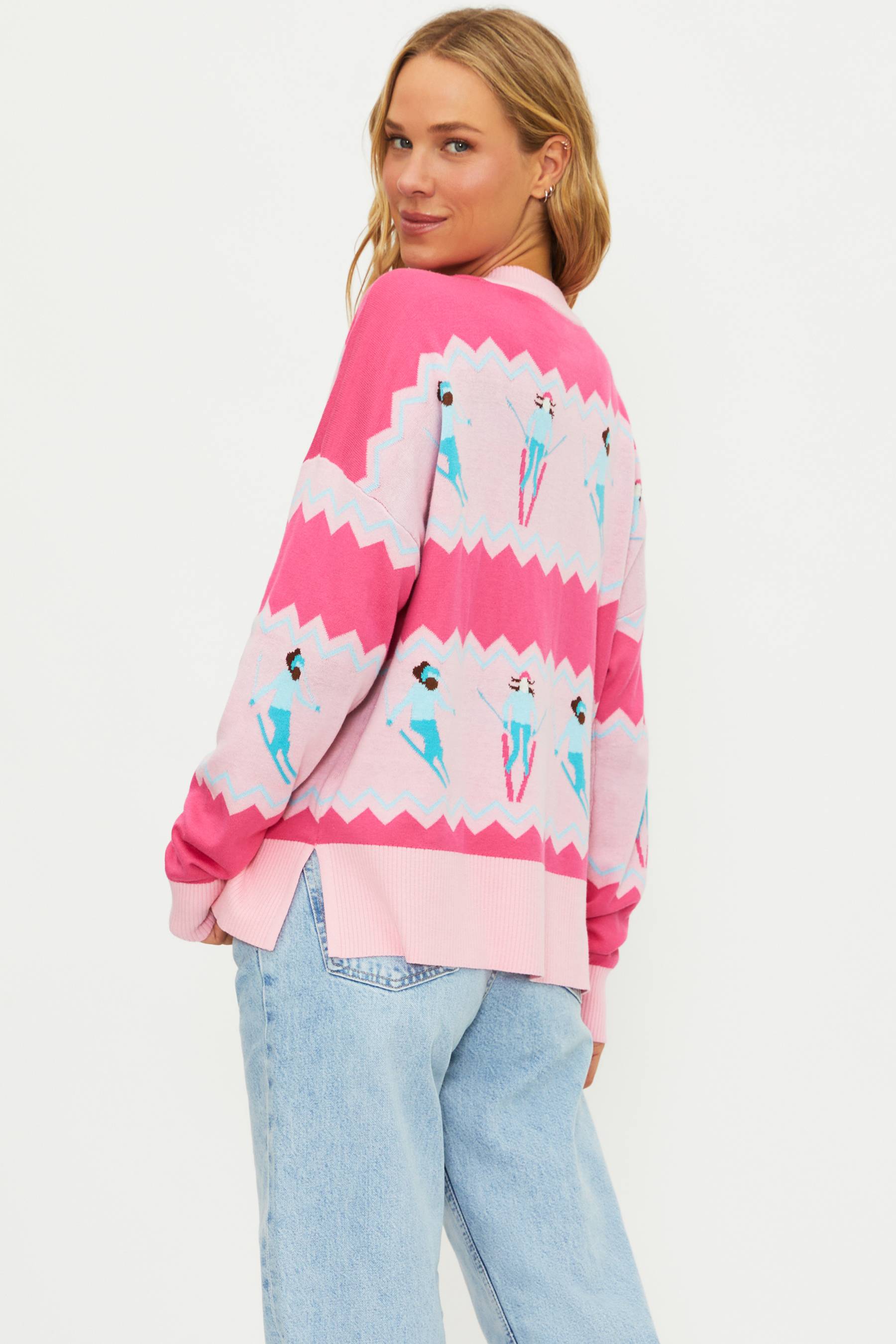 Person wearing a pink sweater with ice cream cone pattern on a white background