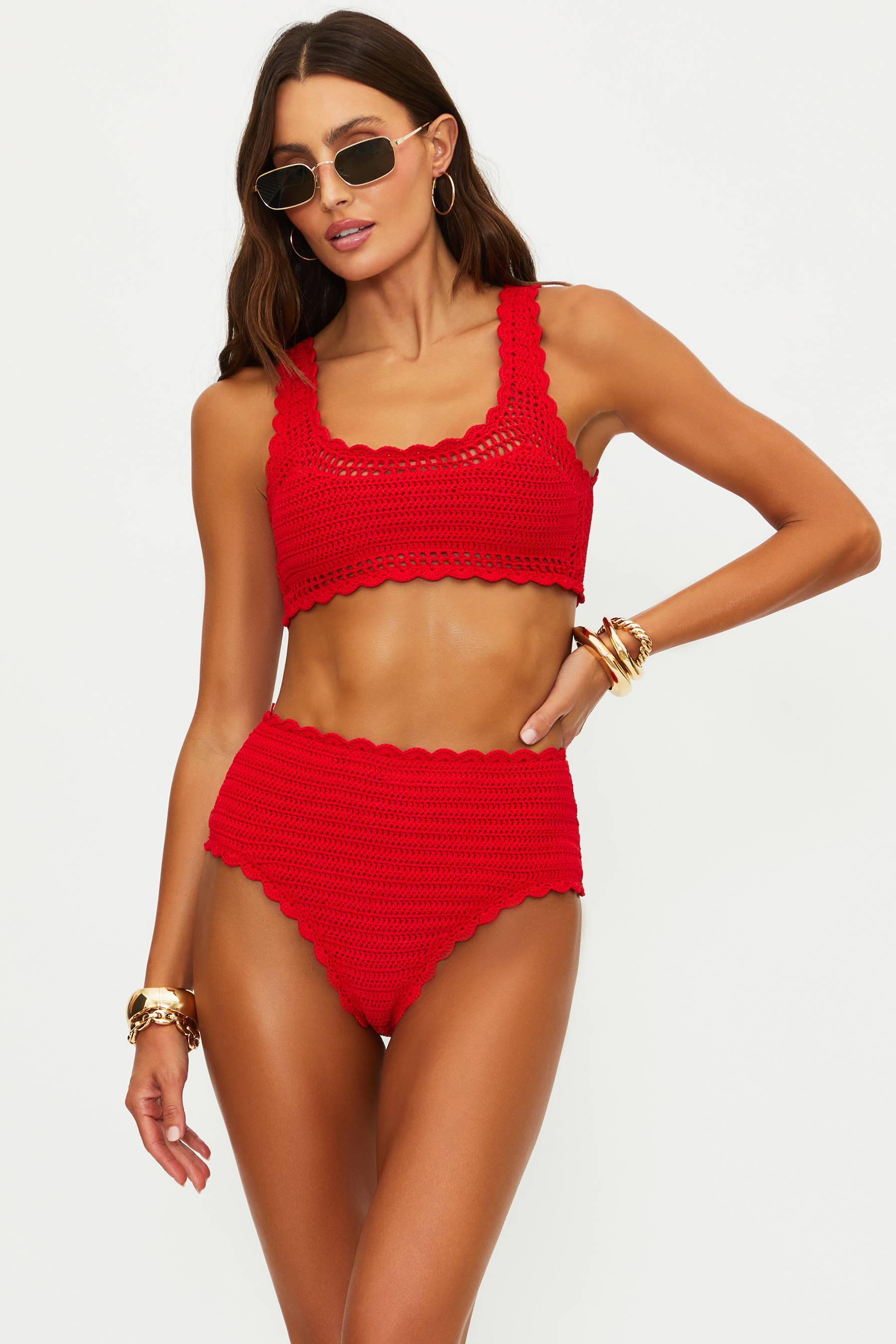 Woman wearing a red crochet bikini set on a white background