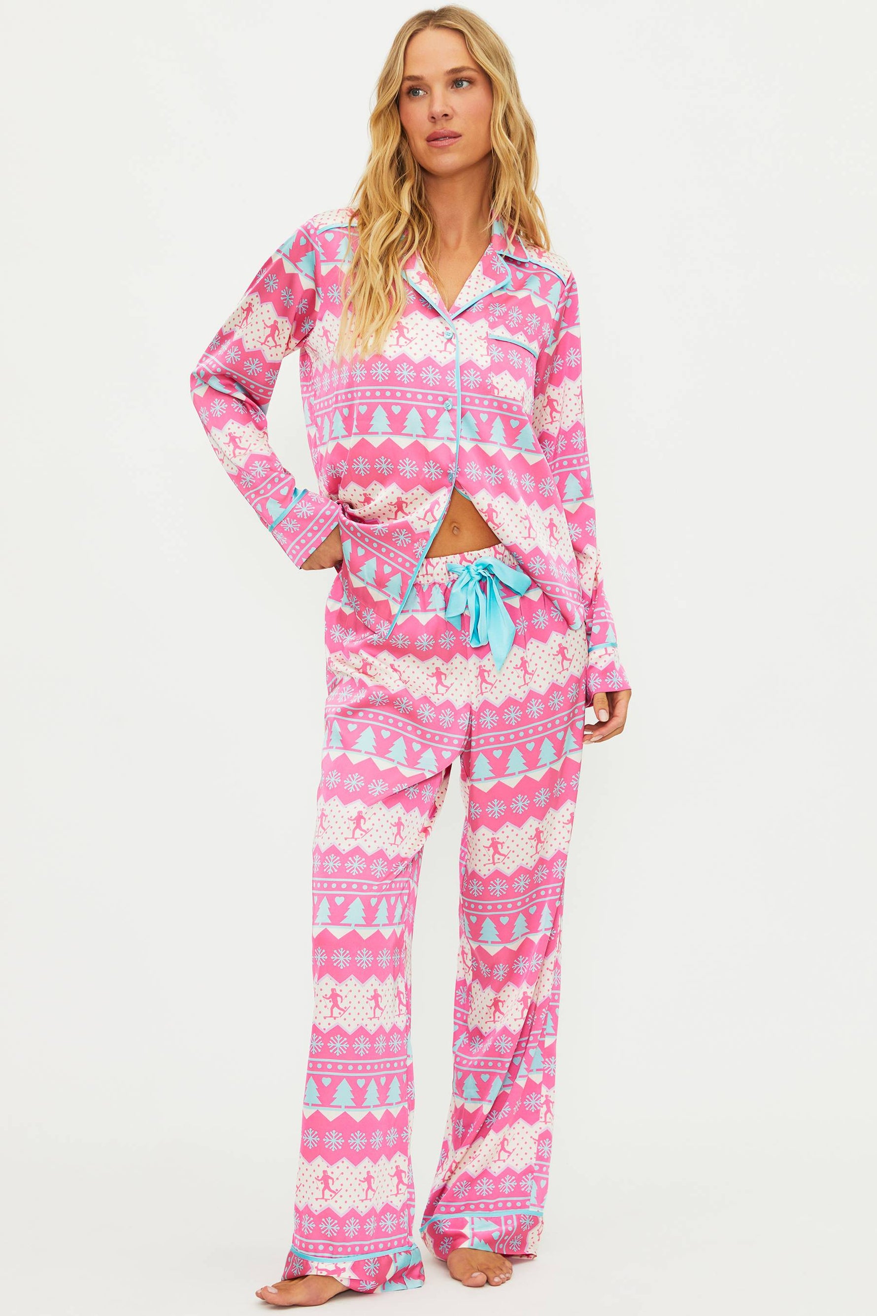 Woman wearing a pink patterned pajama set on a white background