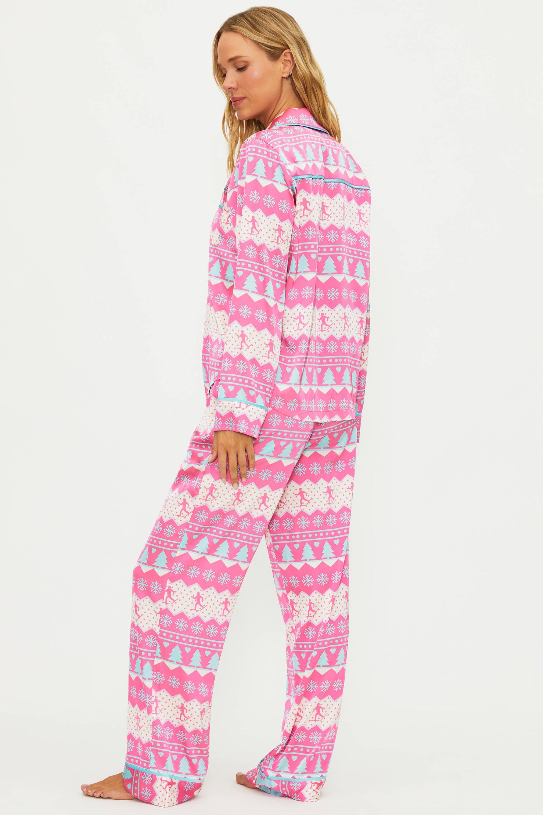 Woman wearing pink and white patterned pajamas on a white background