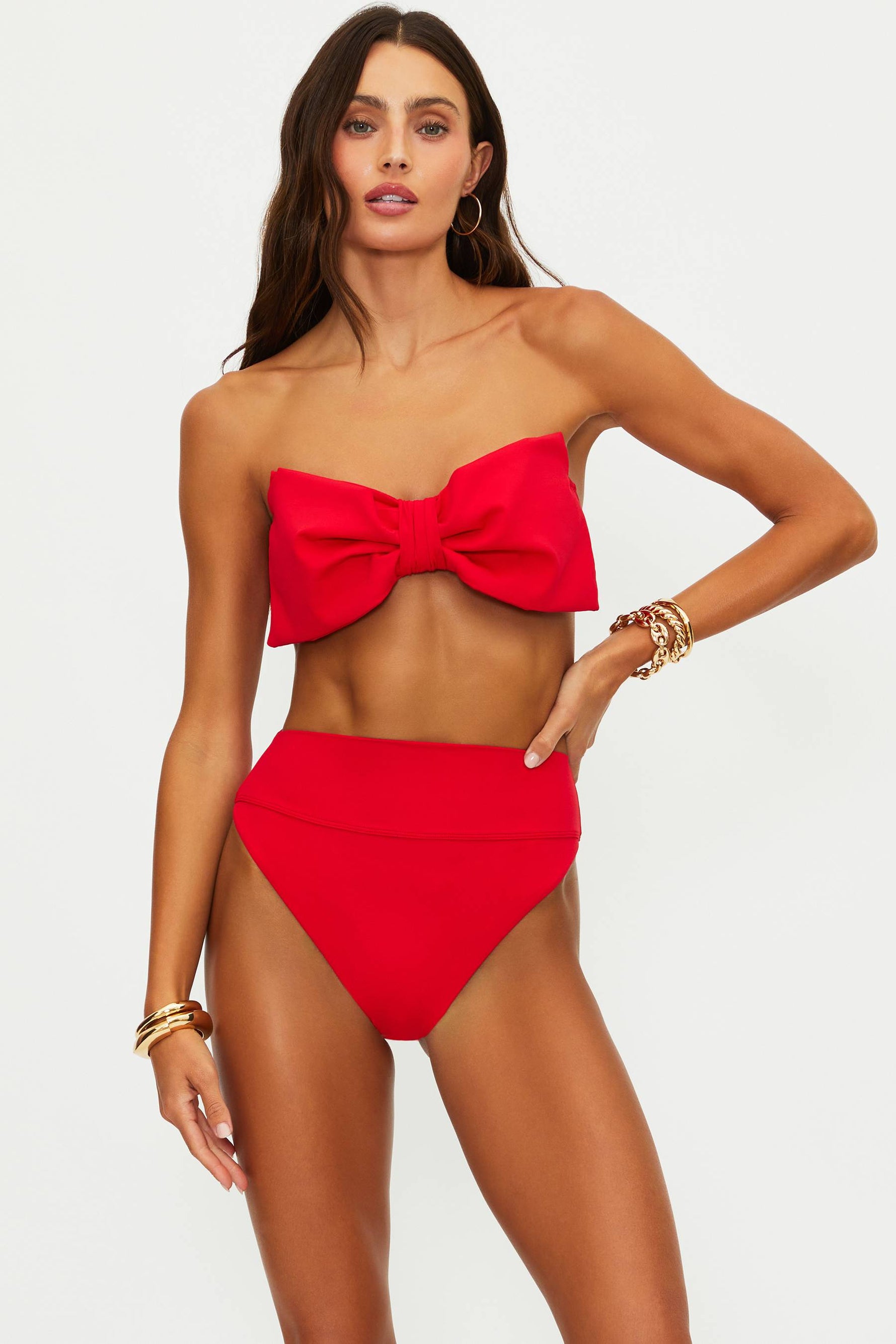 Woman wearing a red bikini with a large bow on a white background
