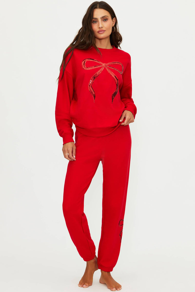 Woman wearing a red outfit with a large bow design on a white background