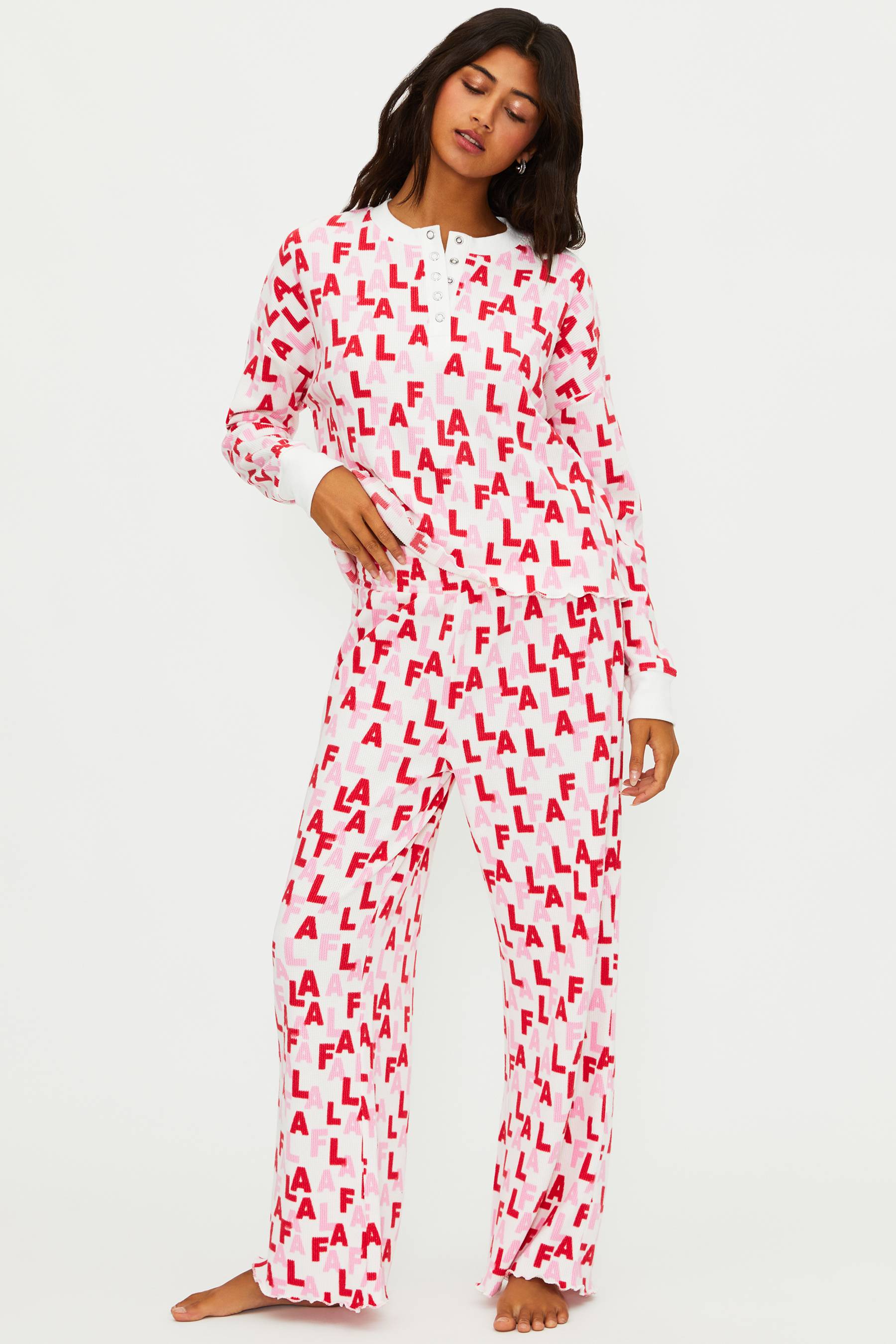 Person wearing a red and white pajama set with 'ALA' pattern on a white background