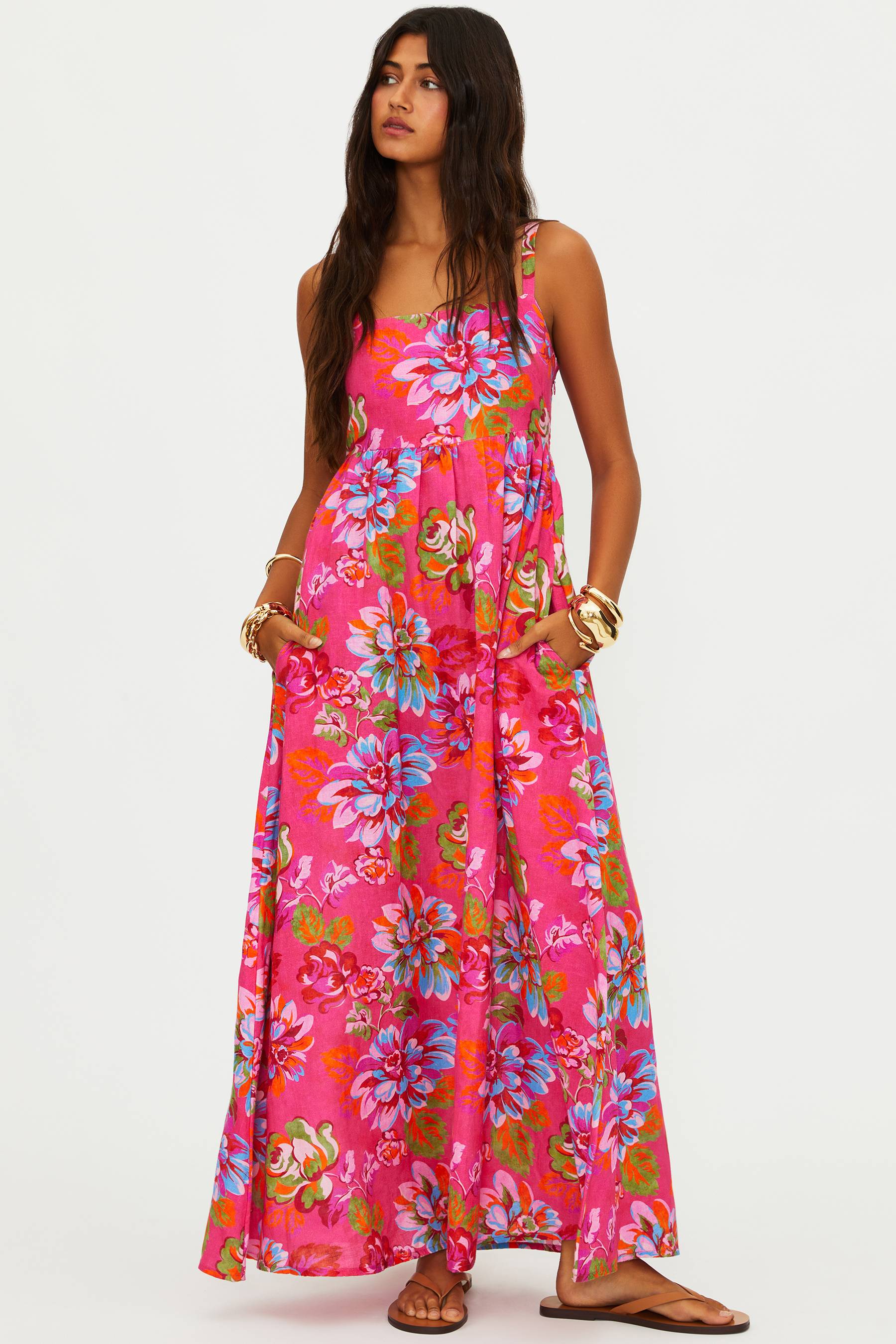 Woman wearing a bright pink floral dress on a white background