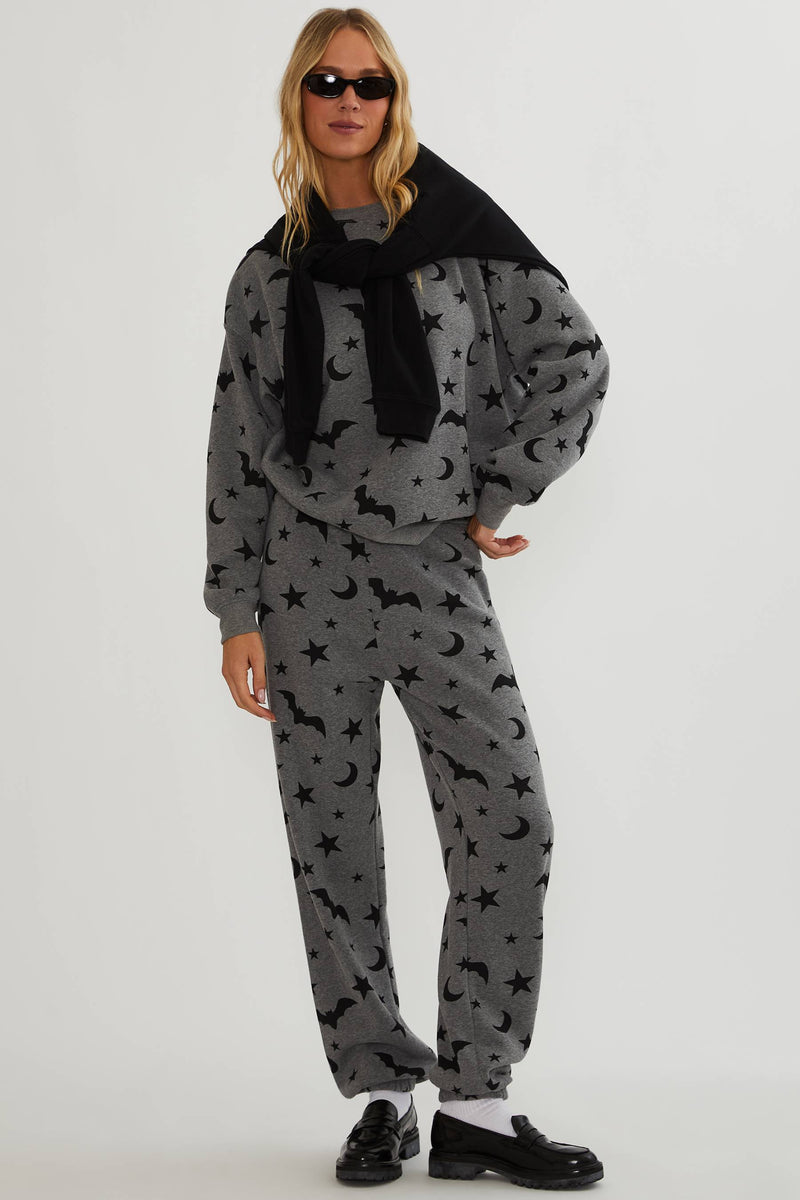Grey sweatpants with black stars, moon, and bats. 