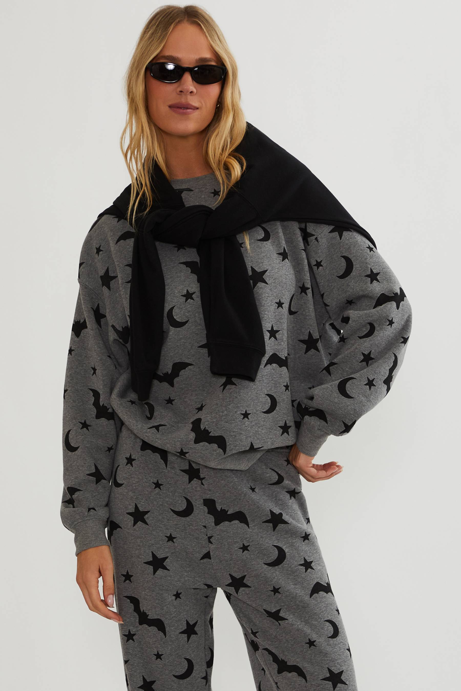 Grey oversized sweatshirt with black bats, stars, and moon. 