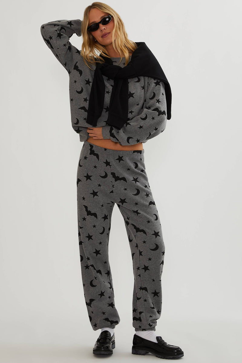 Grey sweatpants with black stars, moon, and bats. 