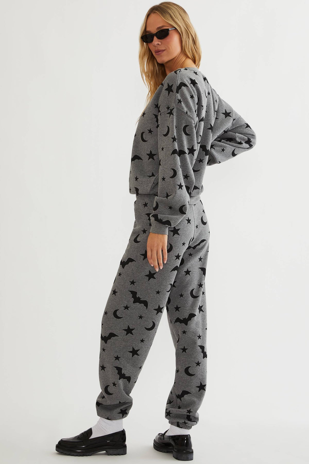 Grey sweatpants with black stars, moon, and bats. 