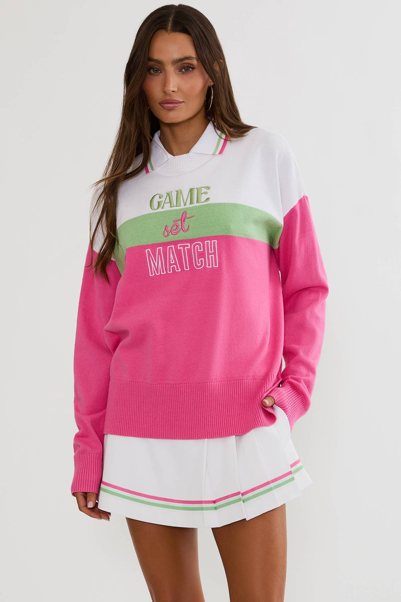 Woman wearing a colorful sweater with 'Game Set Match' text on a white background