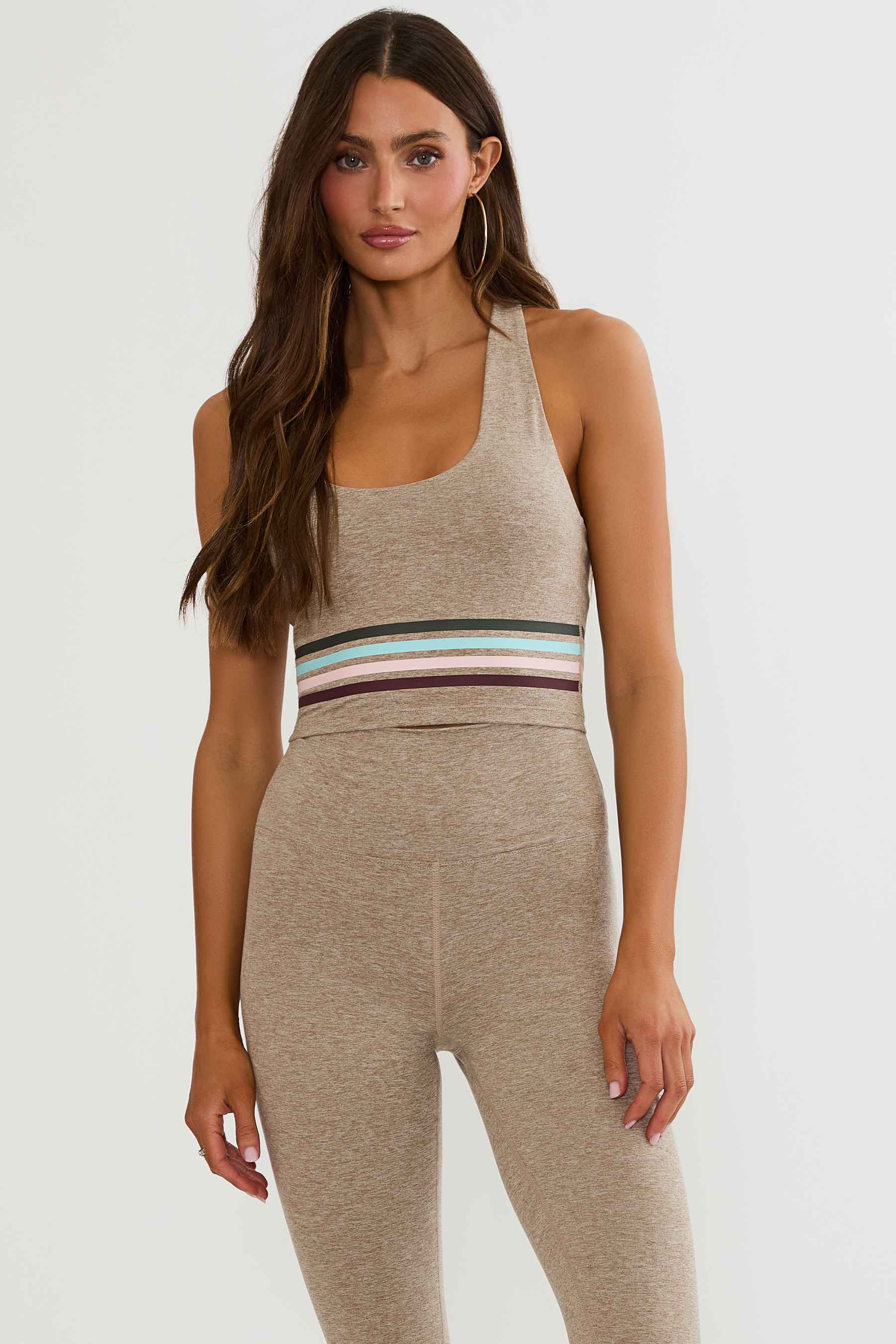 Beige workout top with colorful lining around the ribcage. 
