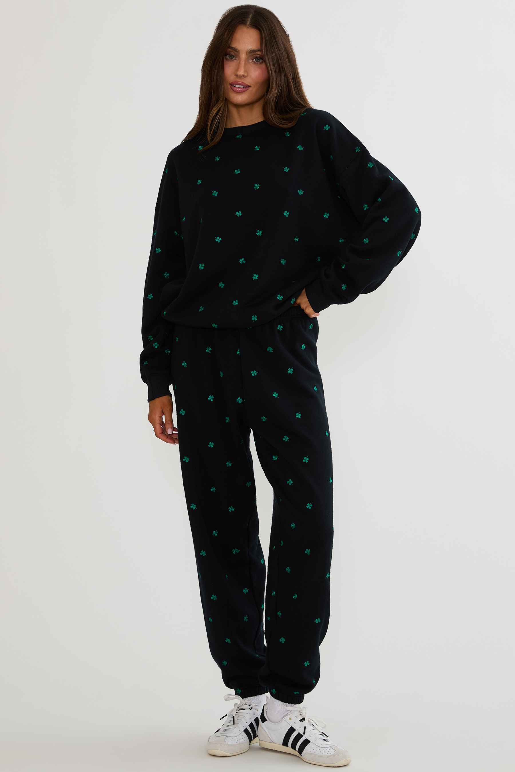 Person wearing a black outfit with green patterns on a white background