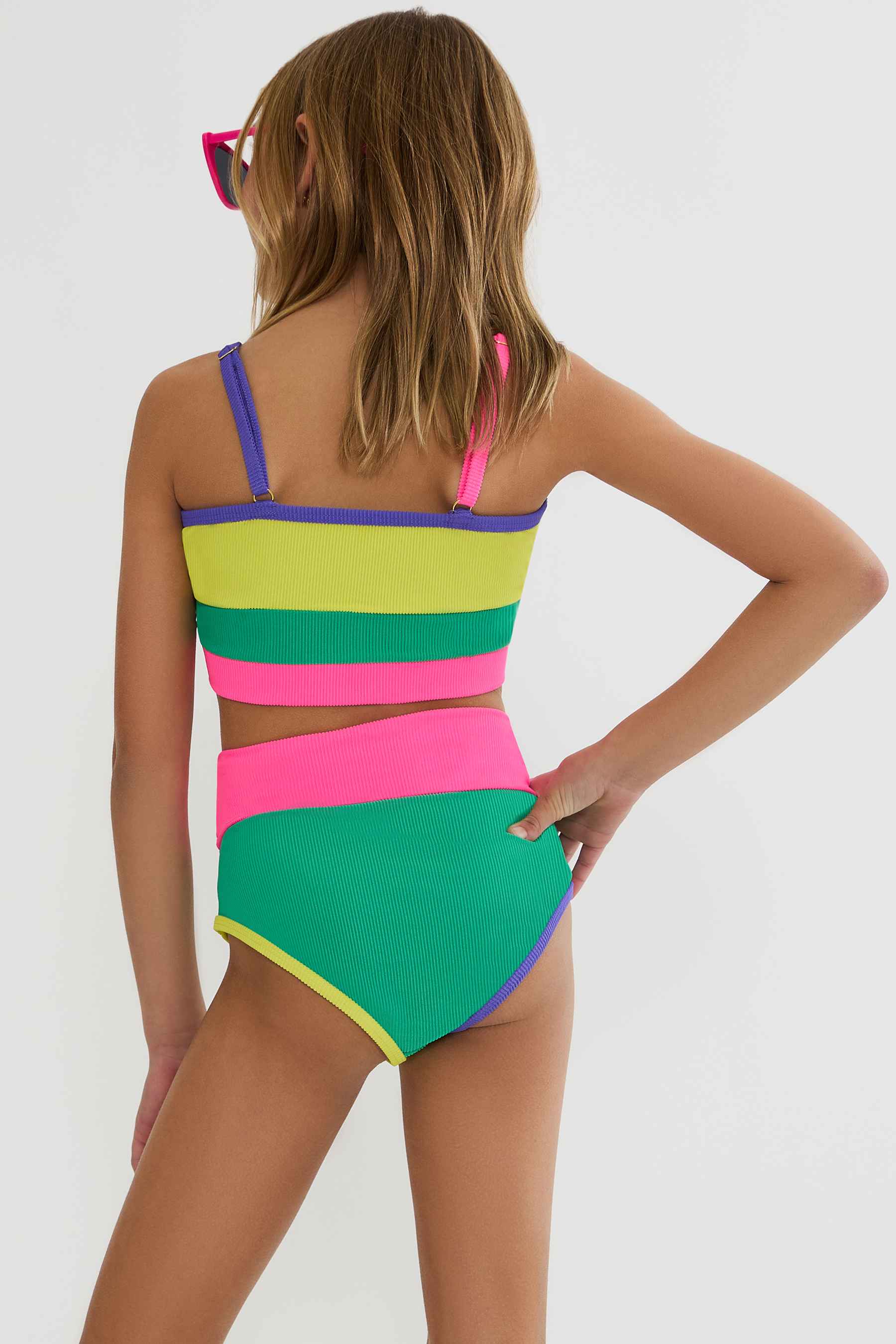 Woman wearing a colorful striped swimsuit on a white background