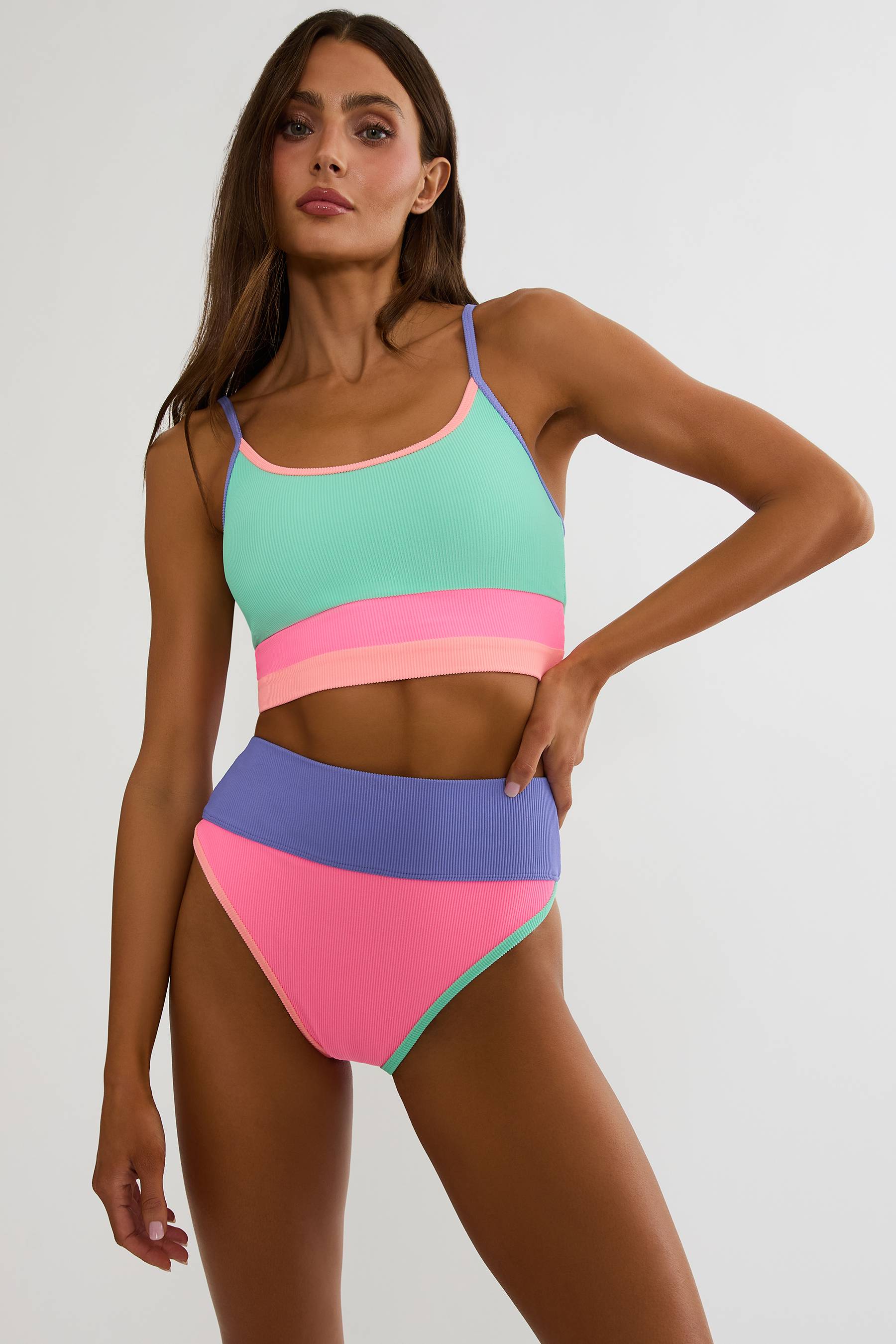 Woman wearing a colorful two-piece swimsuit on a white background