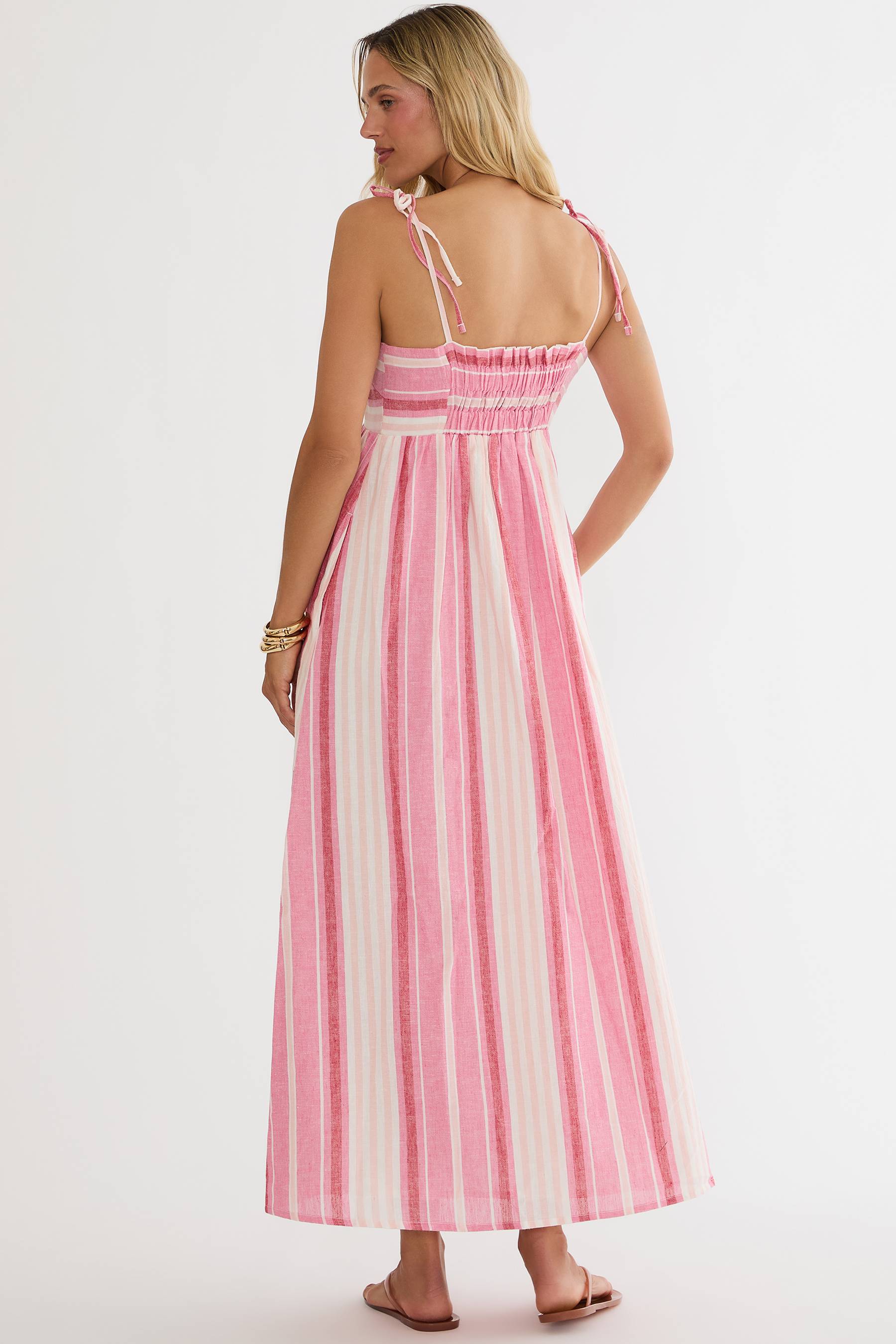 Woman wearing a pink and white striped dress on a white background